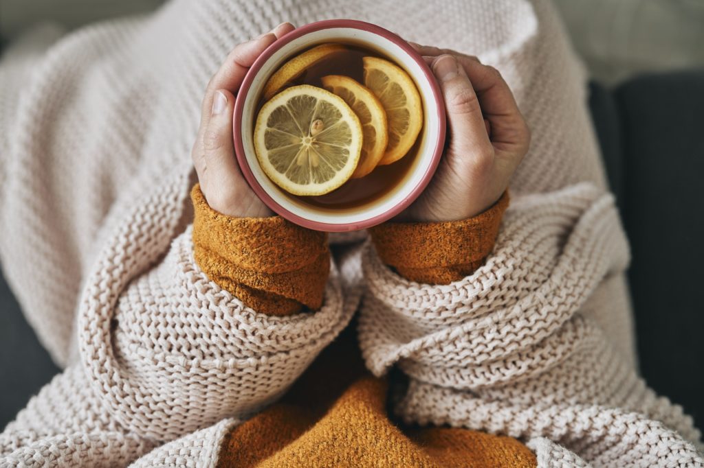 Top view of woman holding cup of hot tea